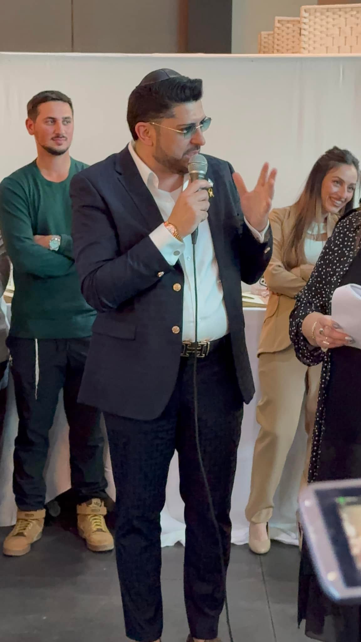אדם שטרית מדבר במיקרופון במהלך פעילות קהילתית
