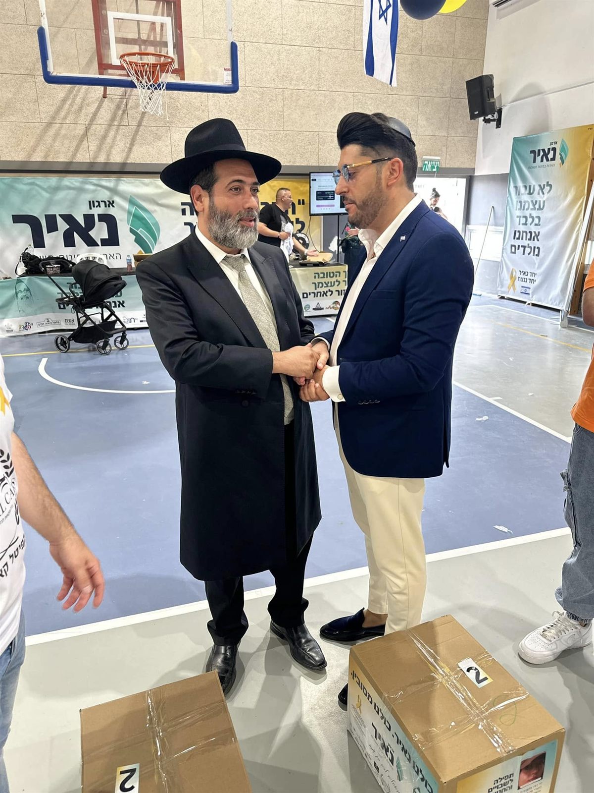 אדם שטרית לוחץ יד ומשוחח עם משתתף בפעילות של ארגון נאיר
