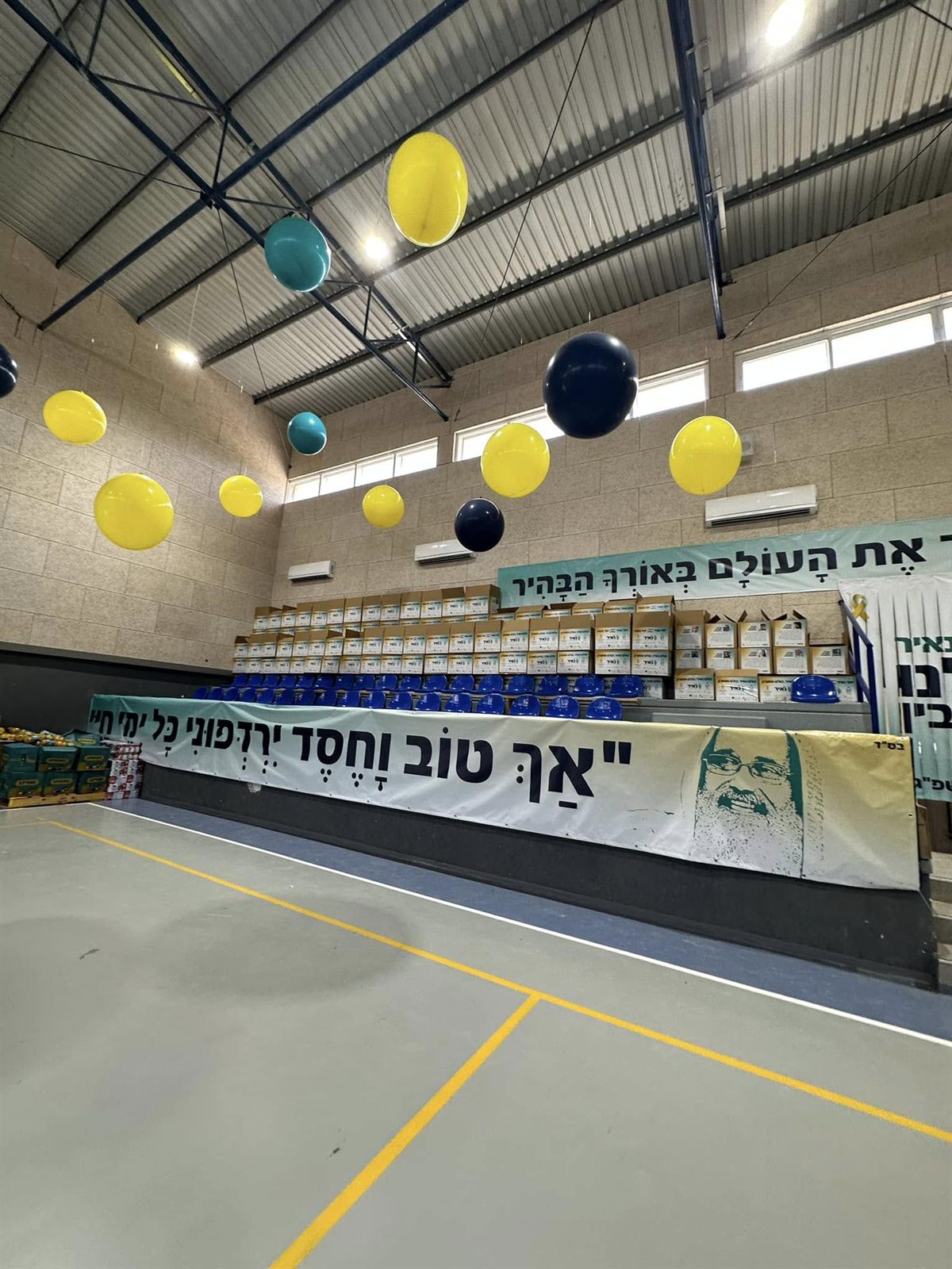 בלונים ושורות של סלי מזון באולם שבו נערכה הפעילות הקהילתית